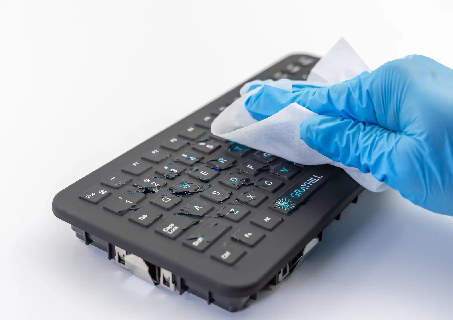 Blue glove cleaning gel off a disinfectable panel-mount Grayhill QWERTY Keyboard