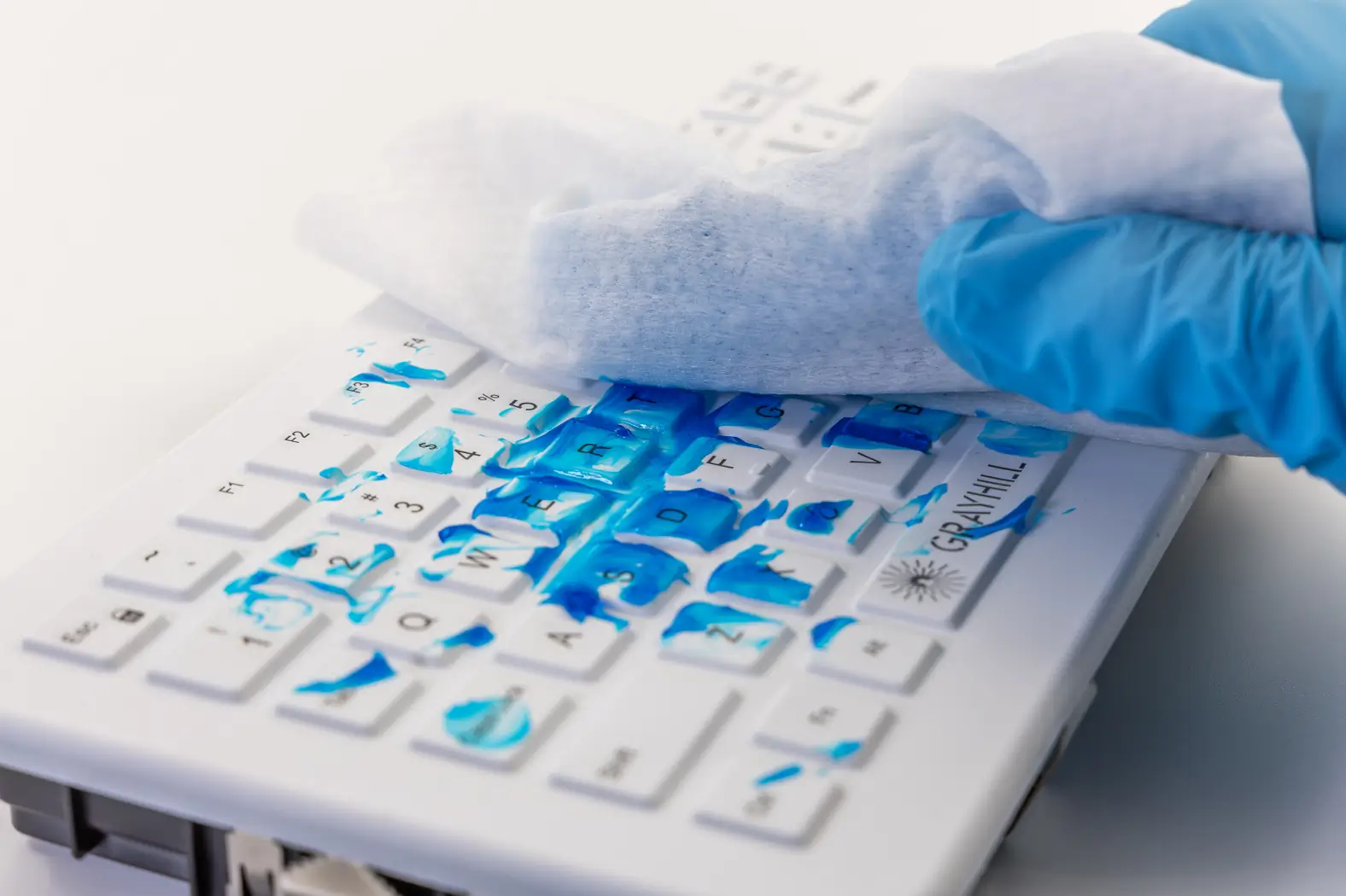 White Grayhill CliniKey Keyboard with blue ultrasound gel and cleaning wipe