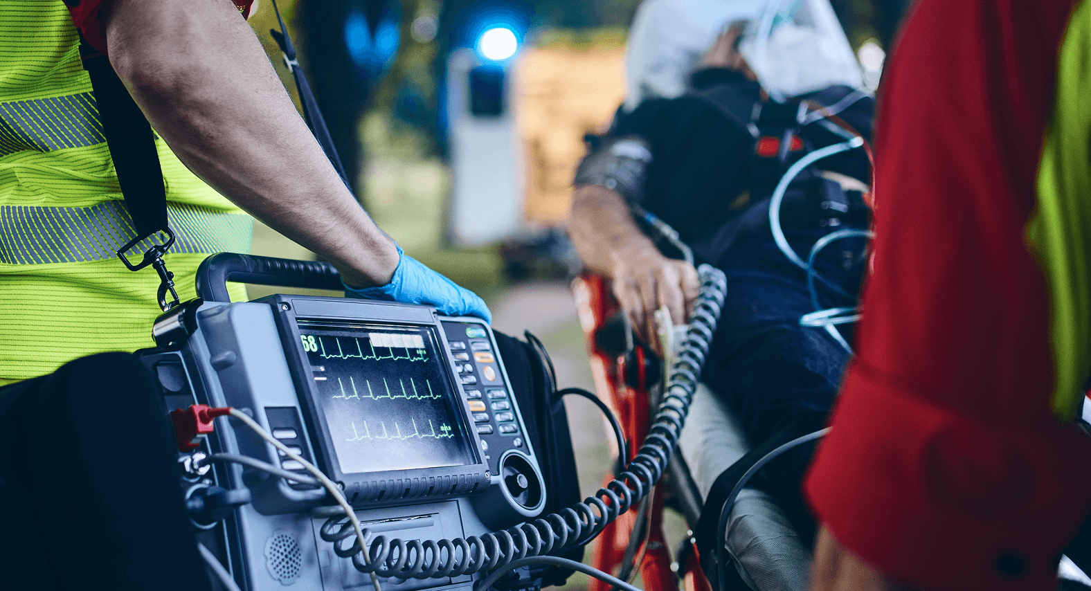 A paramedic relies on a rugged portable medical monitor, showcasing a high-stakes healthcare application where Grayhill's reliable interface components are critical for performance.